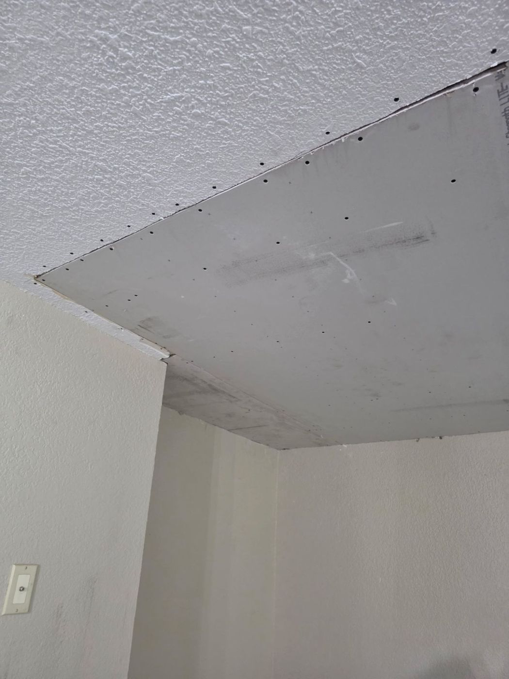 New drywall installed in the repaired ceiling